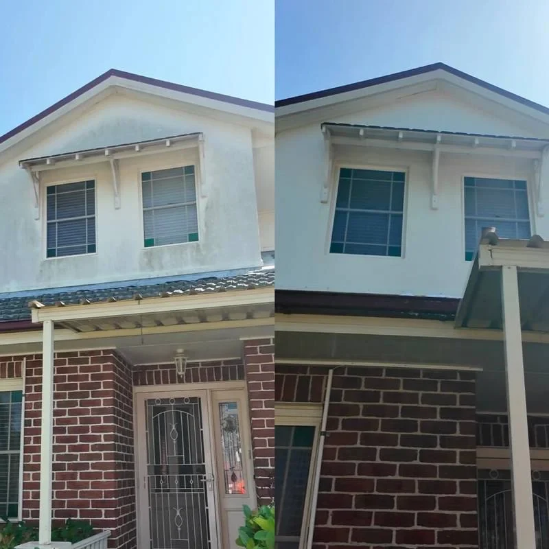 House exterior before and after washing, showing cleaner upper walls and eaves